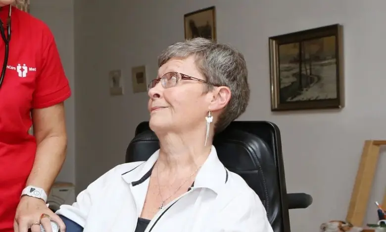 Péče o seniorku doma: měření krevního tlaku.