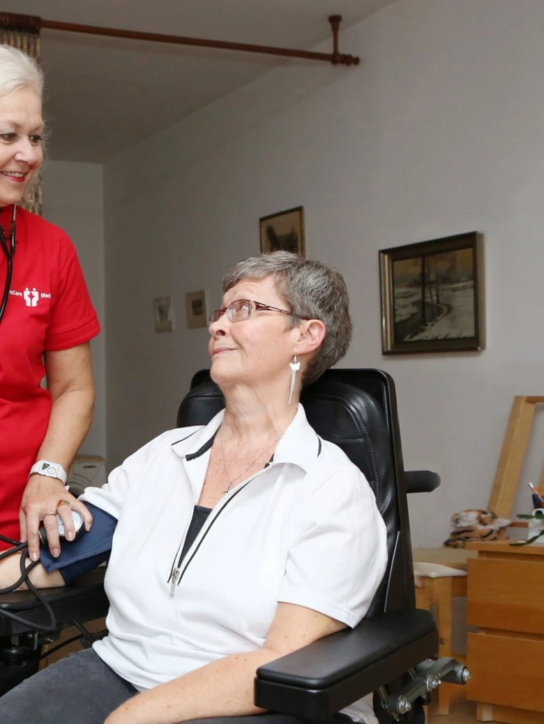 Péče o seniorku doma: měření krevního tlaku.