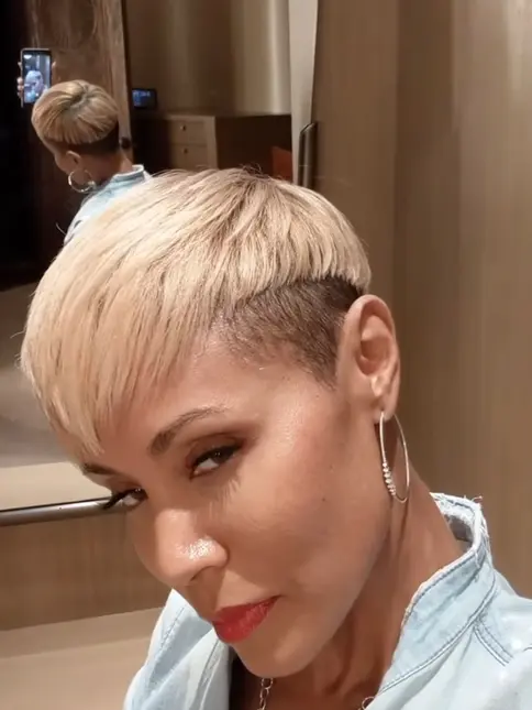 Stylový účes pro ženu po šedesátce s krátkými blond vlasy.