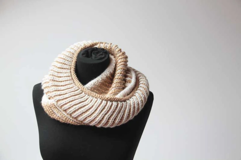 Pletený béžový snood na černém manekenu pro začátečníky.